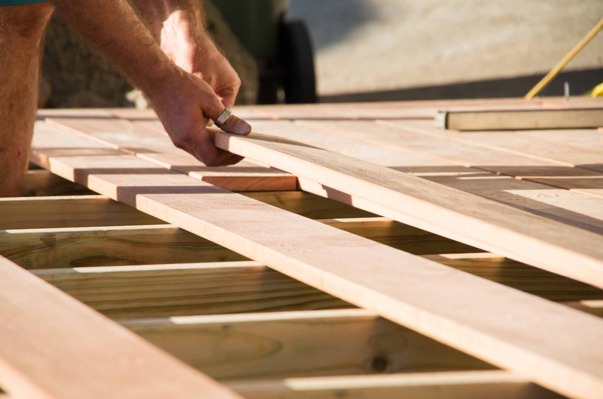 Close up on hands constructing wooden deck