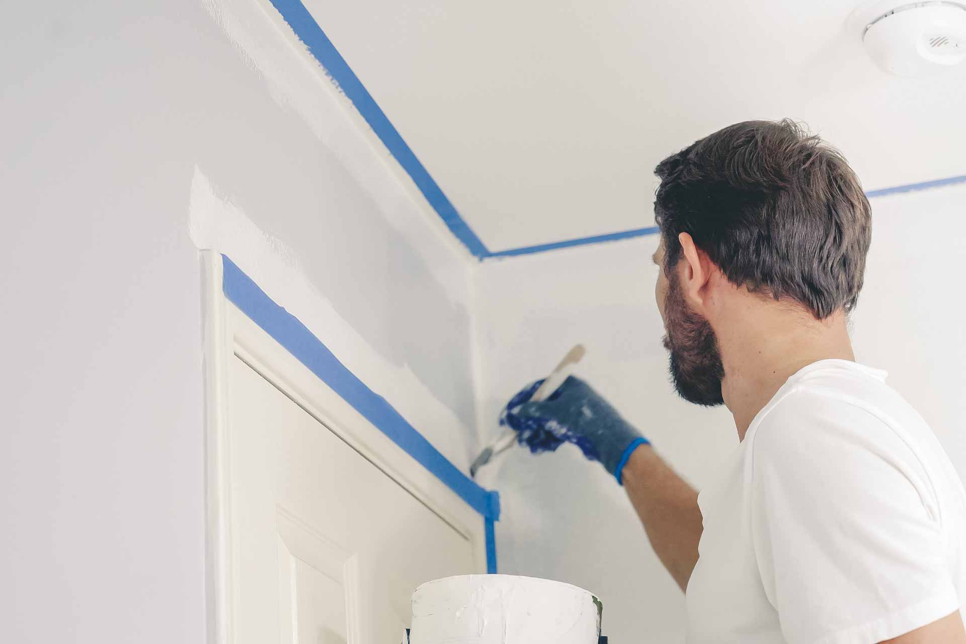 Man painting a wall white