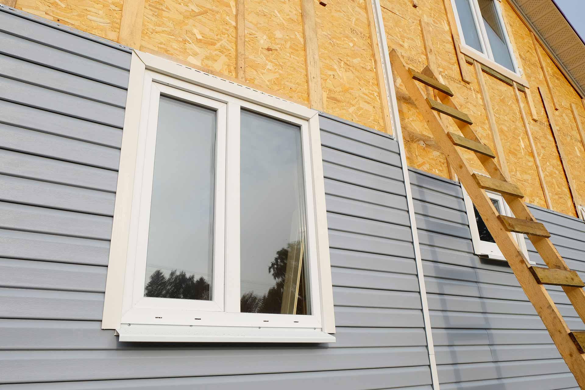 Exterior of a house with in-progress siding installation