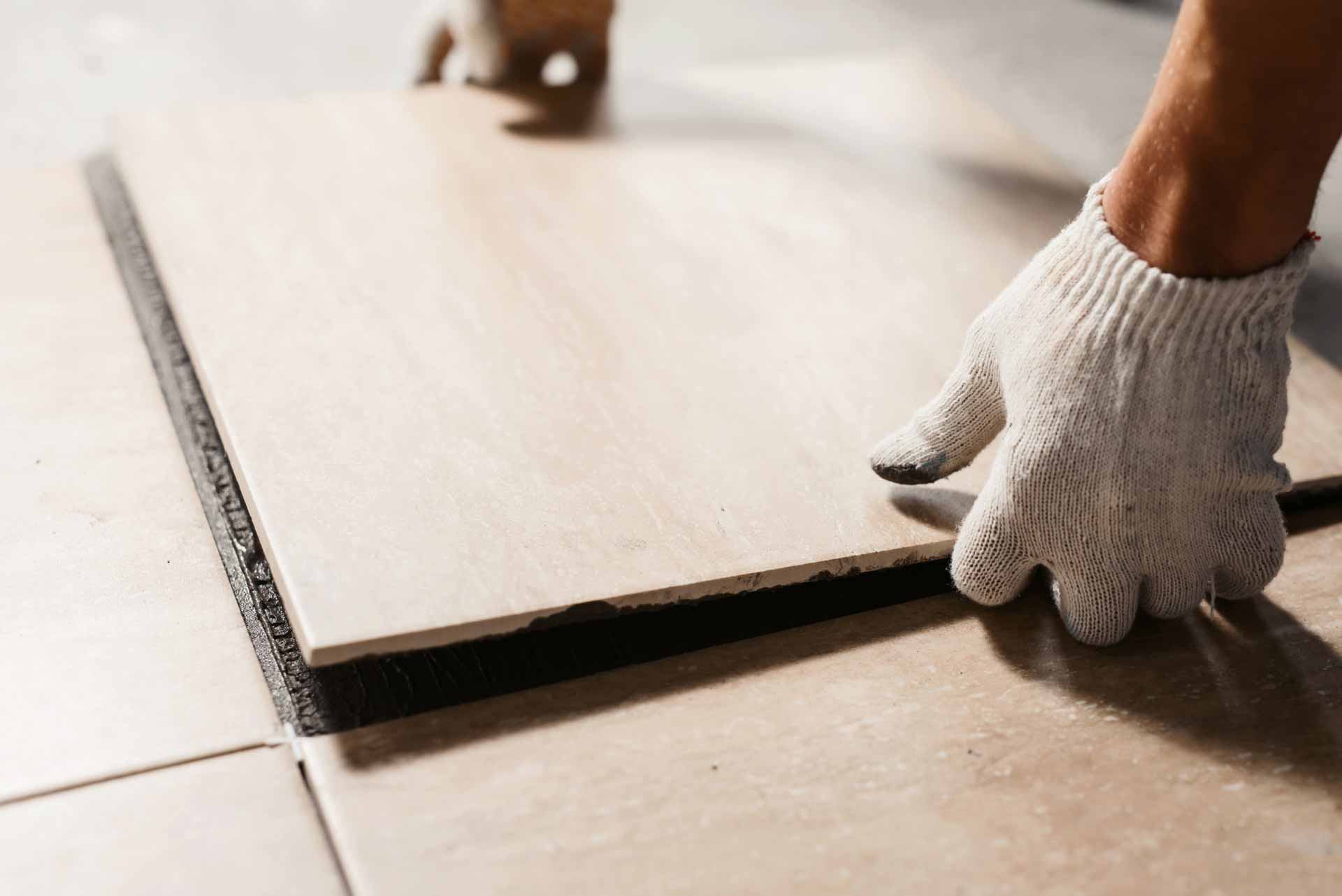 Hands laying ceramic tiles