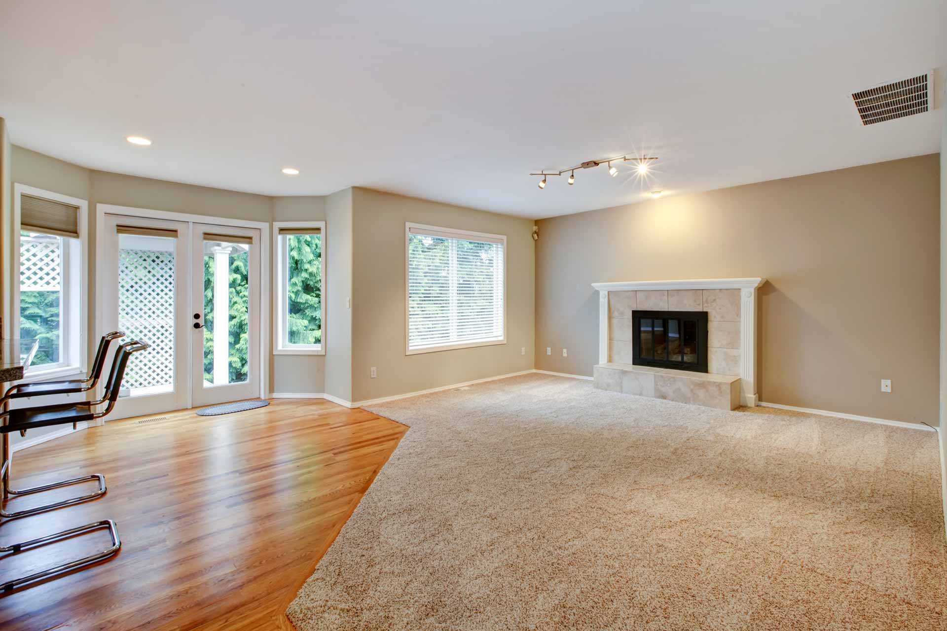 Empty living room with a fireplace and door leading out to back deck
