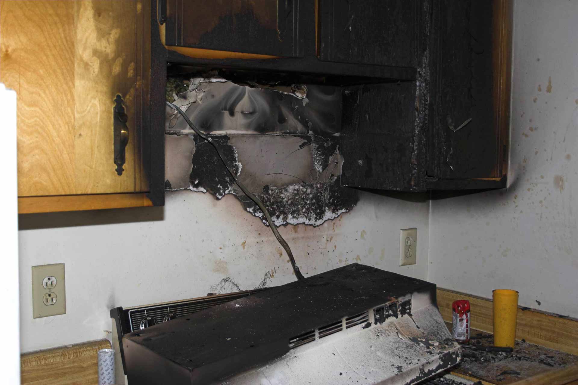 Aftermath of a kitchen fire. The stove's vent hood has fallen off of the wall