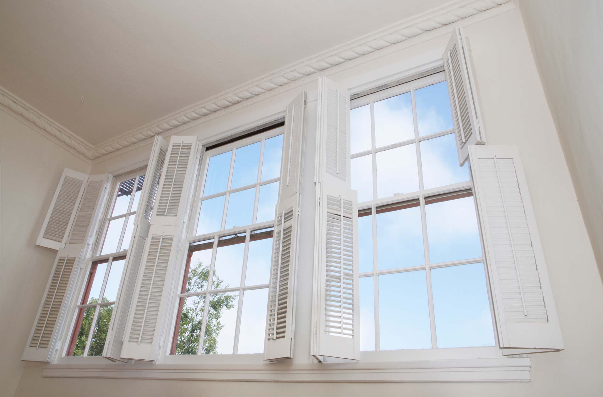 Large windows with interior decorative shutters